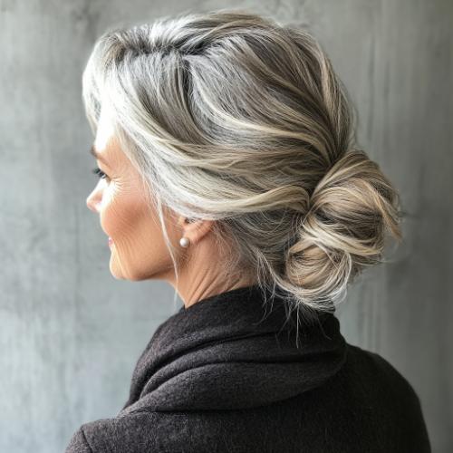 Long hairstyles for women over 60 featuring a messy low chignon bun