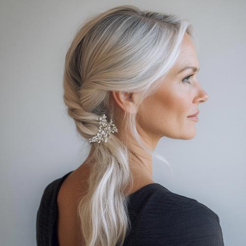 Side-swept ponytail for a woman over 50 with gray-blonde hair